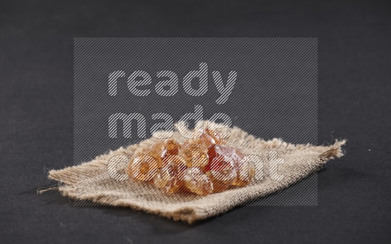 Gum arabic on a burlap piece on black flooring