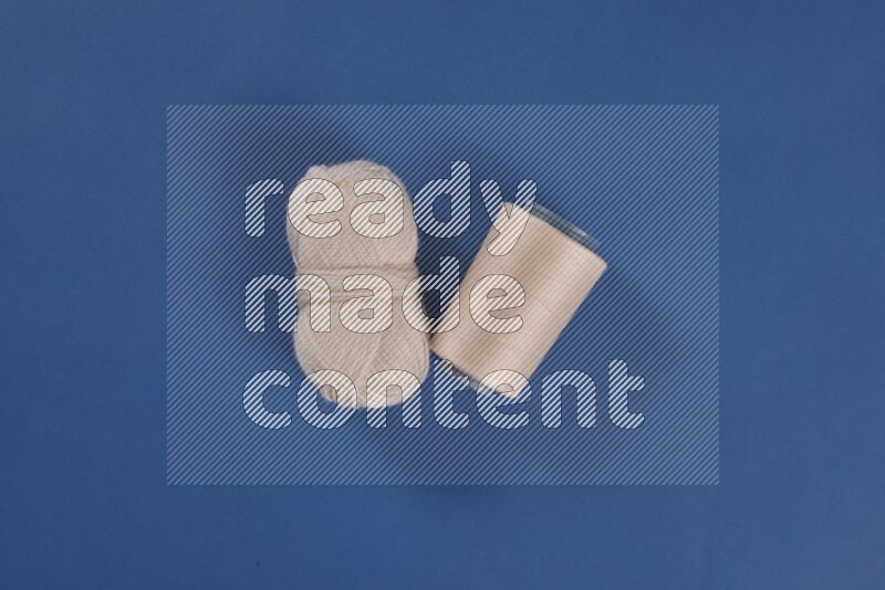 A white collection of sewing and tailoring tools arranged on a blue background