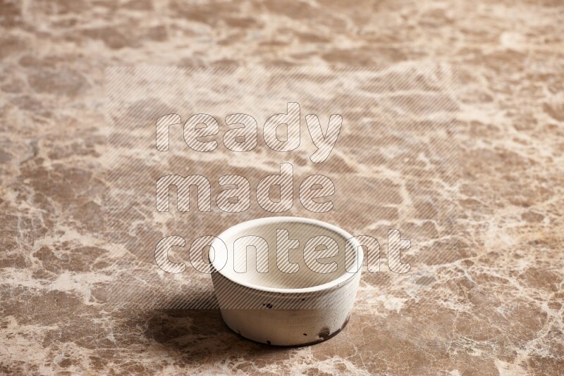 A white pottery bowl on beige marble background