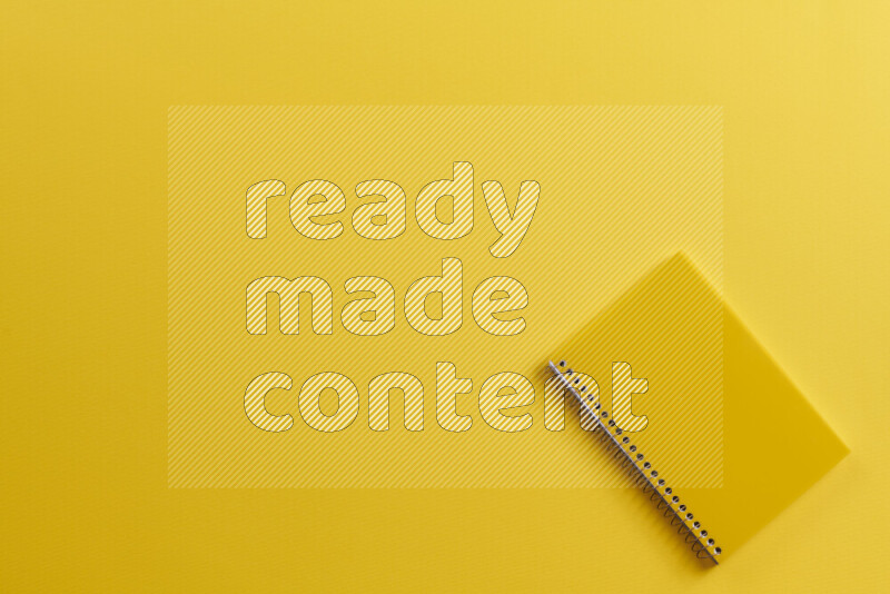 دفتر أصفر مع مستلزمات مدرسية مختلفة على خلفية صفراء