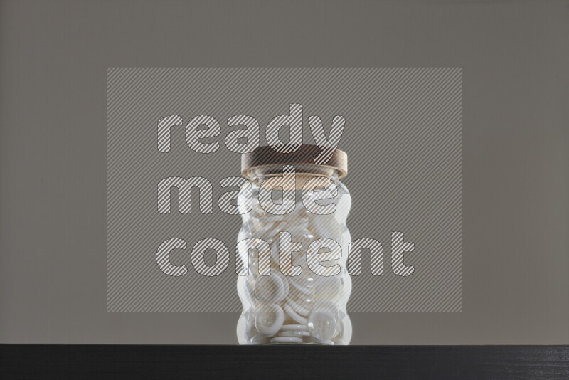 Buttons in a glass jar on black background