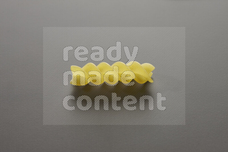 Fusilli pasta on grey background