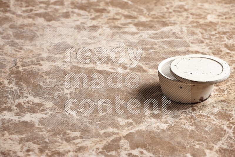 A white pottery bowl on beige marble background