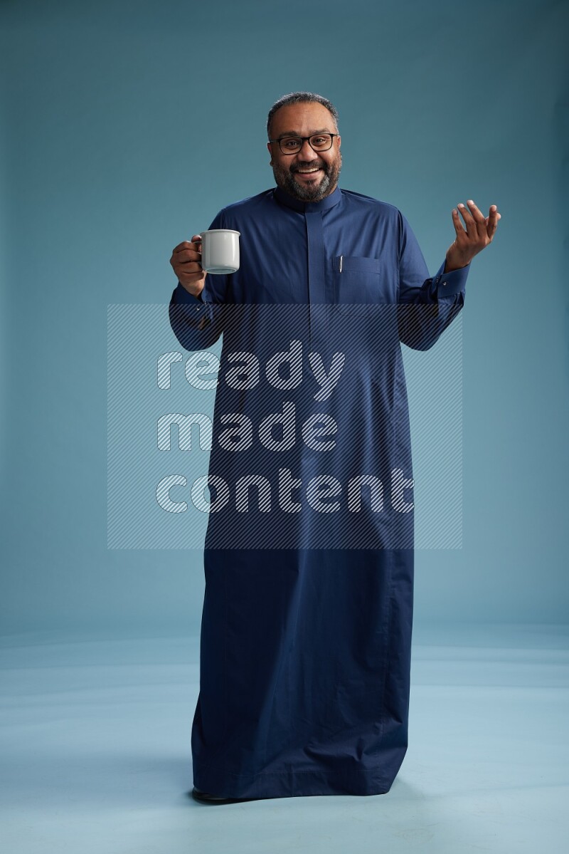 Saudi Man without shimag Standing drinking coffee on blue background