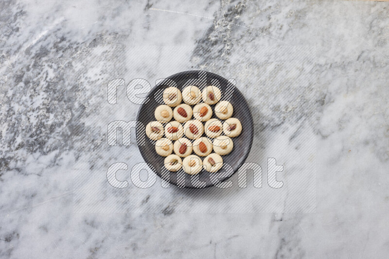 Ghoriba step by step with its ingredient, flour, powdered sugar, ghee and nuts on grey marble background