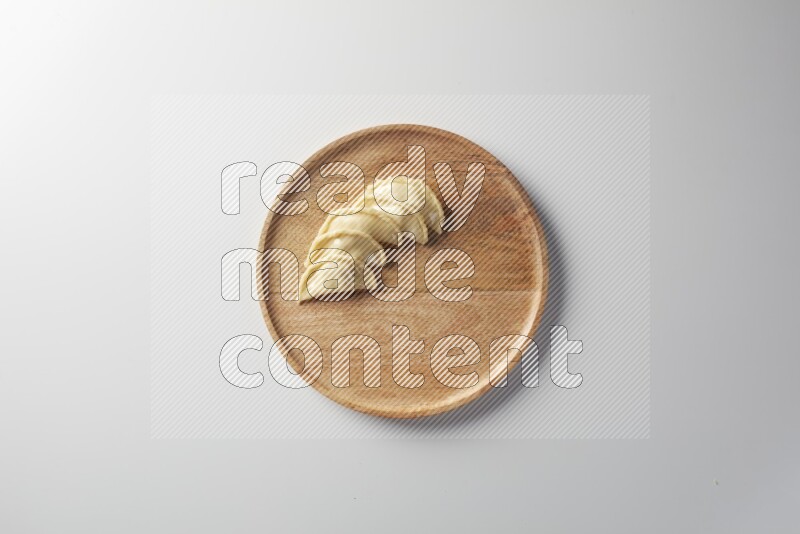 Five Sambosas on a wooden round plate on a white background