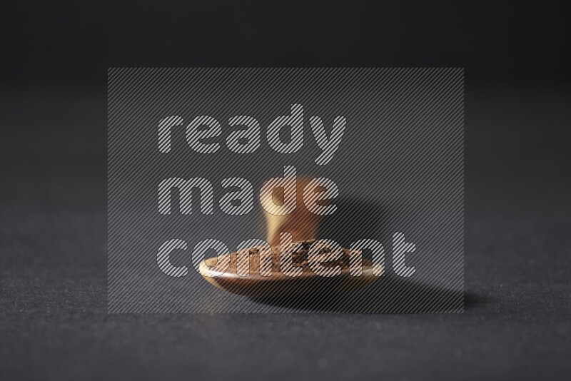 بودرة القرنفل في ملعقة خشبية علي خلفية سوداء