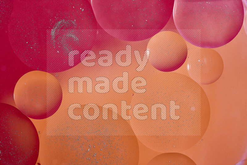 لقطات مقربة لفقاعات من الزيت على سطح الماء باللون الأحمر والبرتقالي والوردي