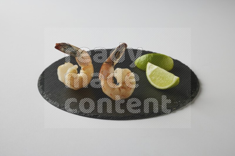 two grilled shrimp  on a black slate direct  on a white back ground
