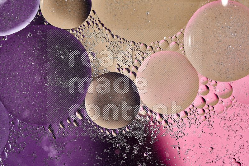 لقطات مقربة لفقاعات من الزيت على سطح الماء باللون البني والأرجواني والوردي