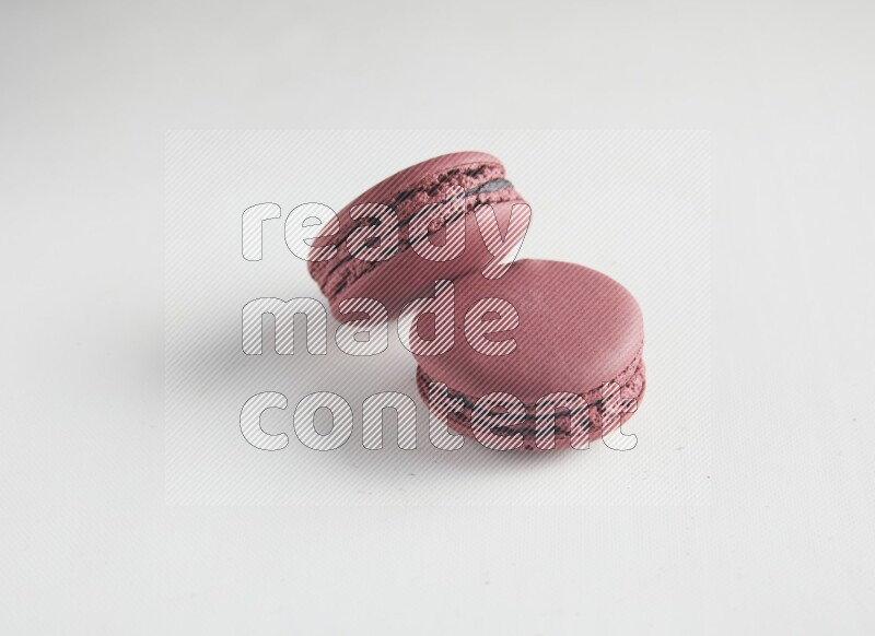 45º Shot of two Red Cherry macarons on white background