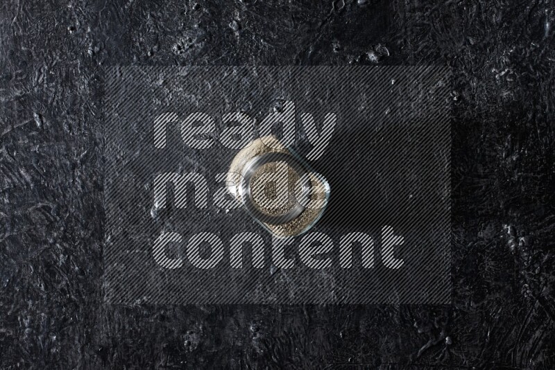 وعاء زجاجي ممتلئ بالفلفل الأبيض على أرضية سوداء