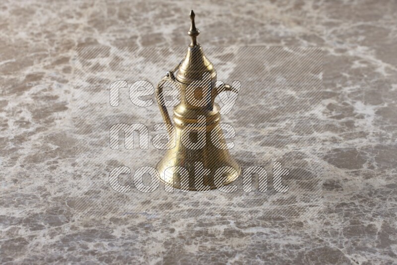 A metal turkish pot for coffee on beige marble background