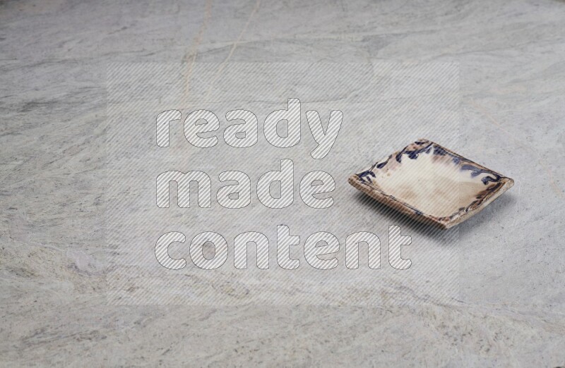 A decorative pottery plate on grey marble background