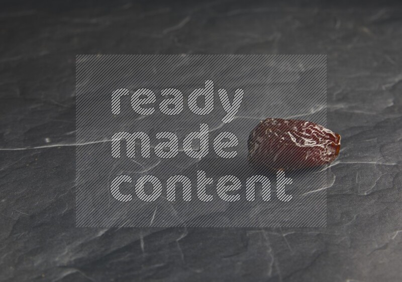 one madjoul date on a black textured background