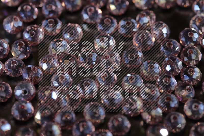 Rose transparent crystal beads scattered on a black background