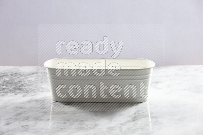 An empty white plant pot on grey marble background