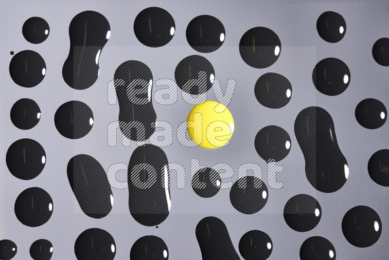 Close-ups of abstract yellow and black paint droplets on the surface