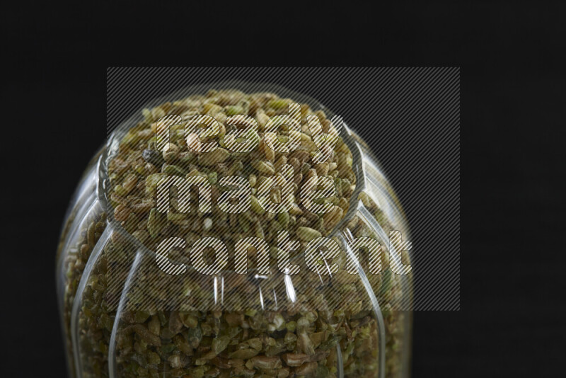 Freekeh in a glass jar on black background