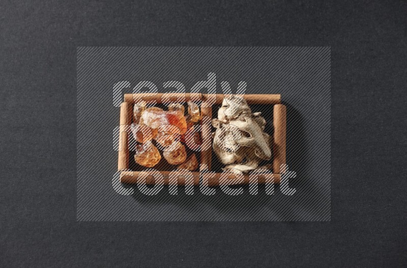 2 squares of cinnamon sticks full of dried ginger and gum arabic on black flooring