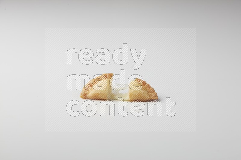 One cheese sambosa cut in half on a white background