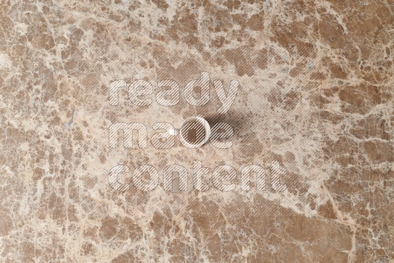 A pottery cup on beige marble background