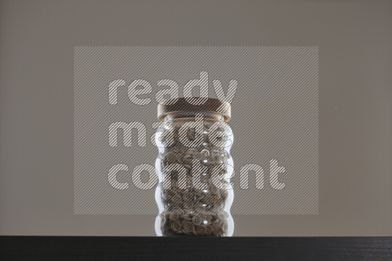 Buttons in a glass jar on black background