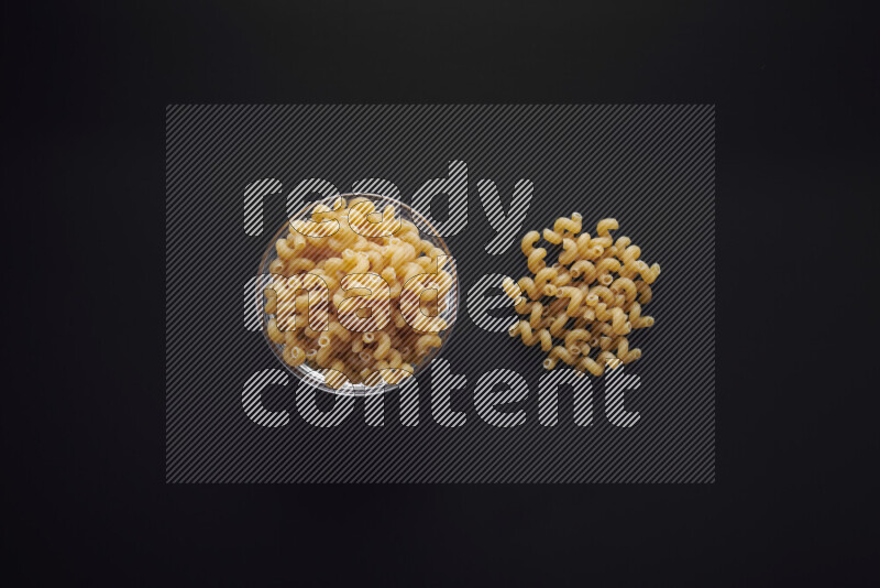 Twist pasta in a glass bowl on black background