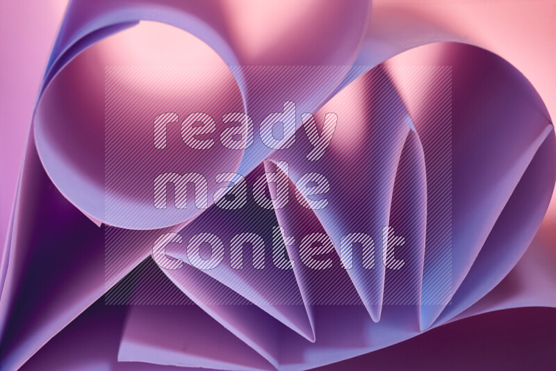 An artistic display of paper folds creating a harmonious blend of geometric shapes, highlighted by soft lighting in purple tones