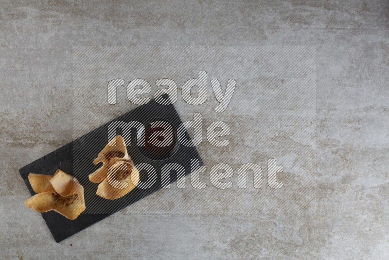 wonton cups with soy sauce ramkin on rectangle slate on grey textured counter top