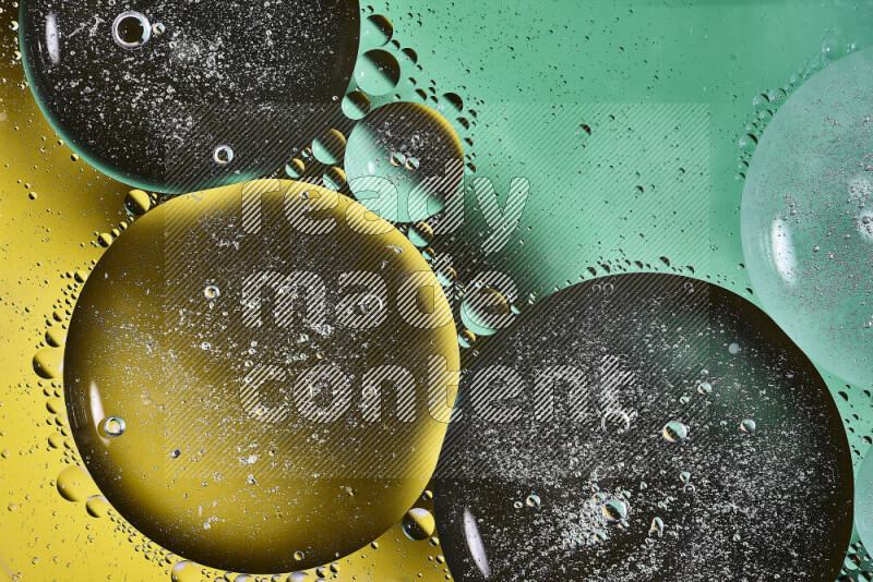 Close-ups of abstract oil bubbles on water surface in shades of green and yellow
