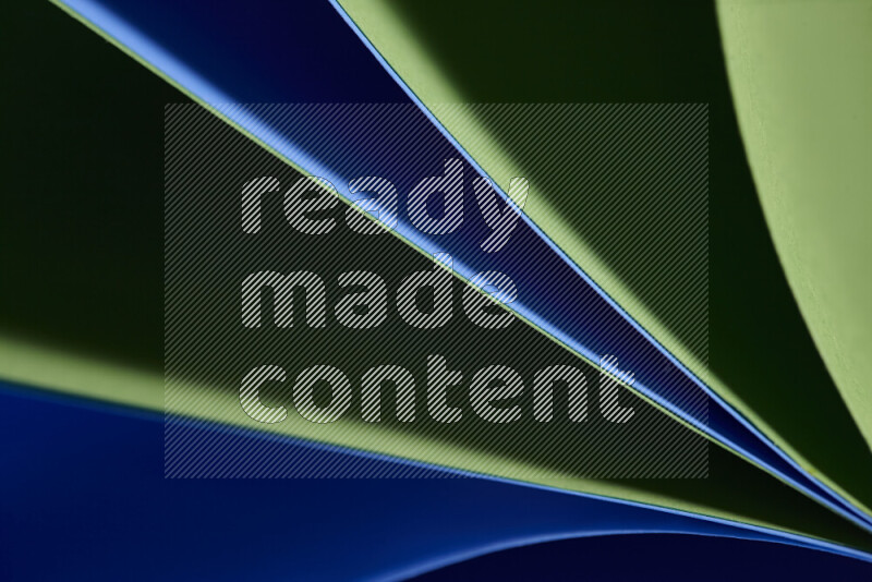 An abstract art showing blue and green paper sheets arranged in an overlapping curves