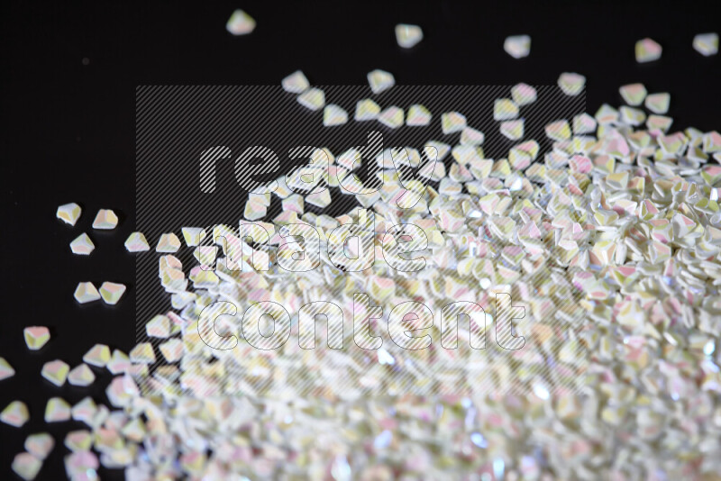 Colorful plastic shards for decoration scattered on a black background