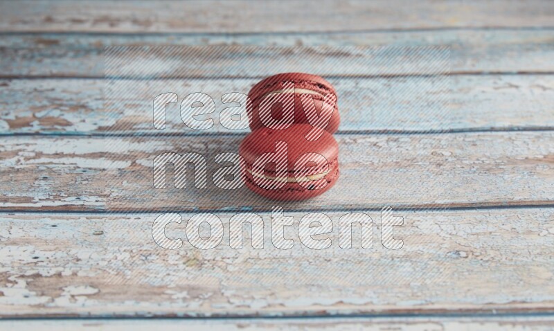 45º Shot of two Red Velvet macarons on light blue wooden background