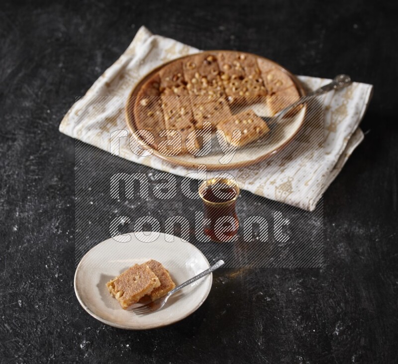 بسبوسة مع الشاي علي خلفية سوداء خشبية