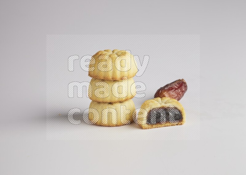 Four Pieces of Maamoul filled with date one of them is cut direct on white background