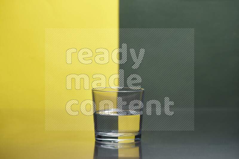 The image features a clear glassware filled with water, set against yellow and dark green background