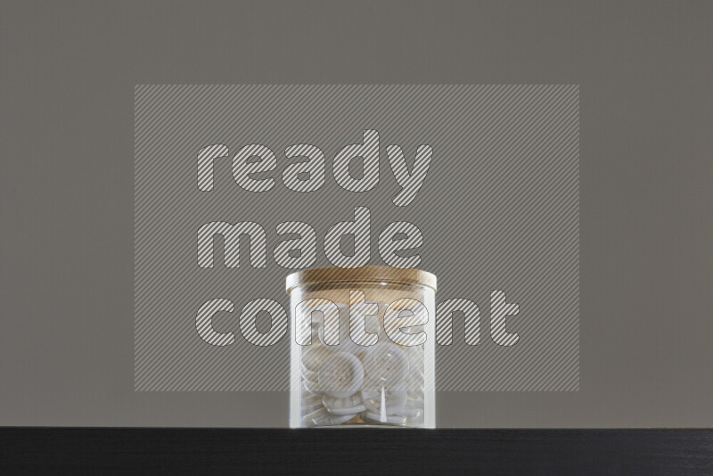 Buttons in a glass jar on black background