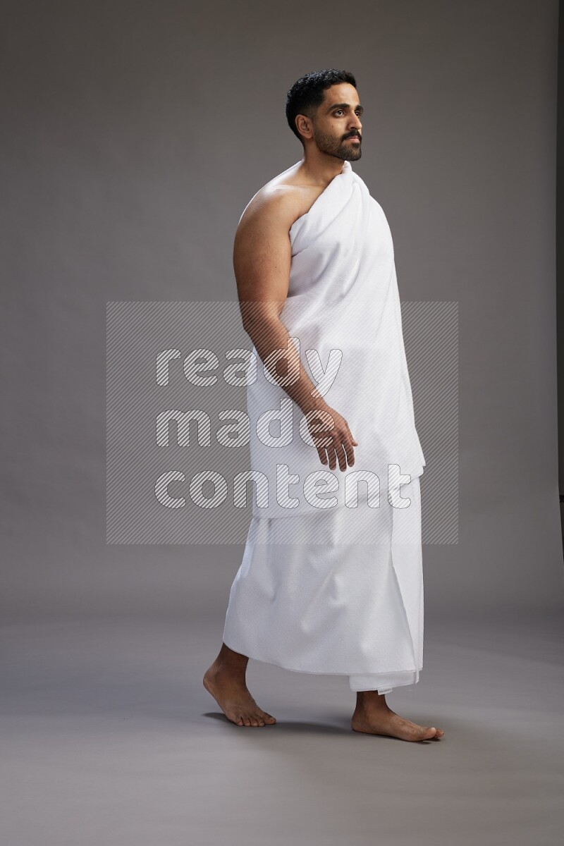 A man wearing Ehram Standing Interacting with the camera on gray background
