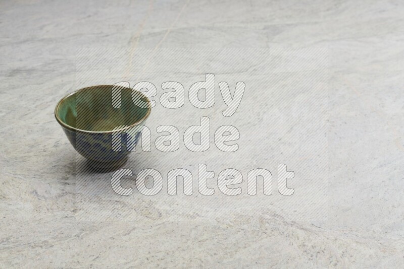 A multicolored pottery bowl on grey marble background