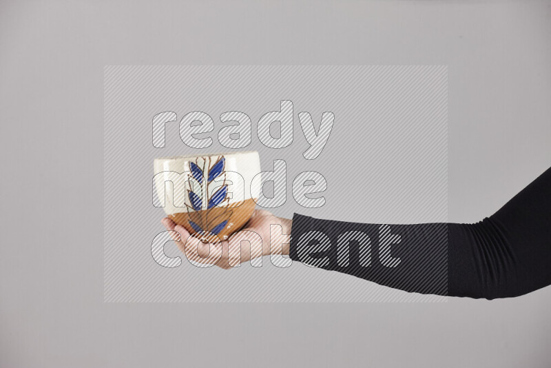 A woman in black abaya holding different pottery essentials in different positions