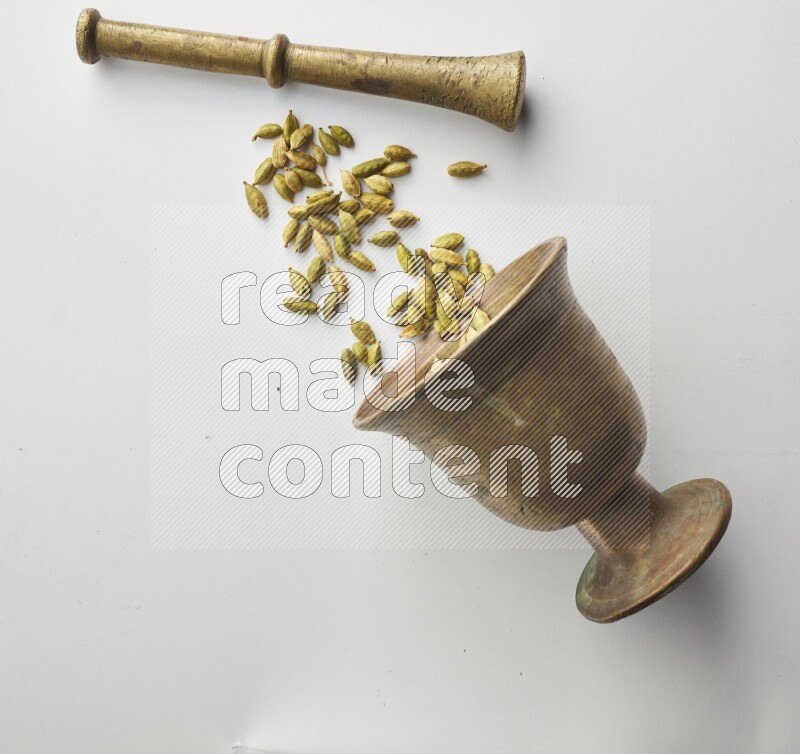 Top-view shot of Cardamon in herbs crusher on white background