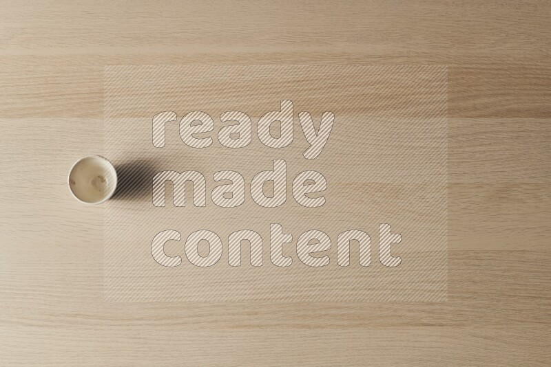 A pottery cup on light wooden background