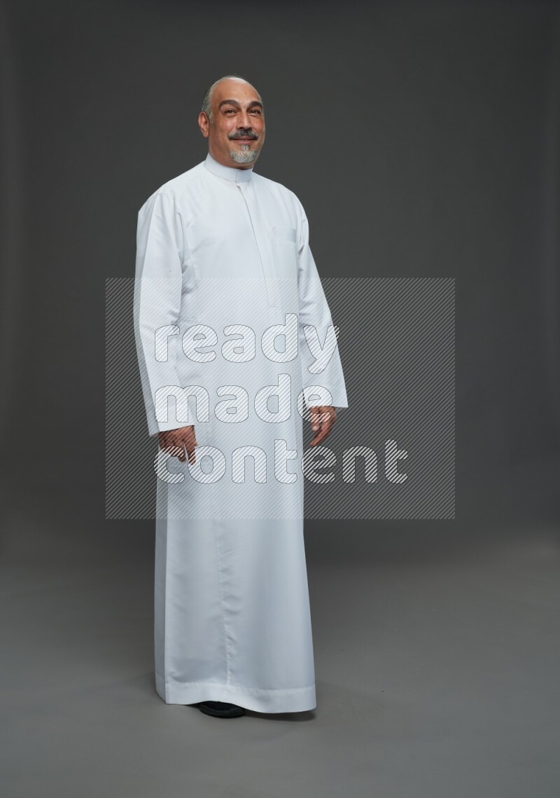 Saudi man without shomag Standing Interacting with the camera on gray background