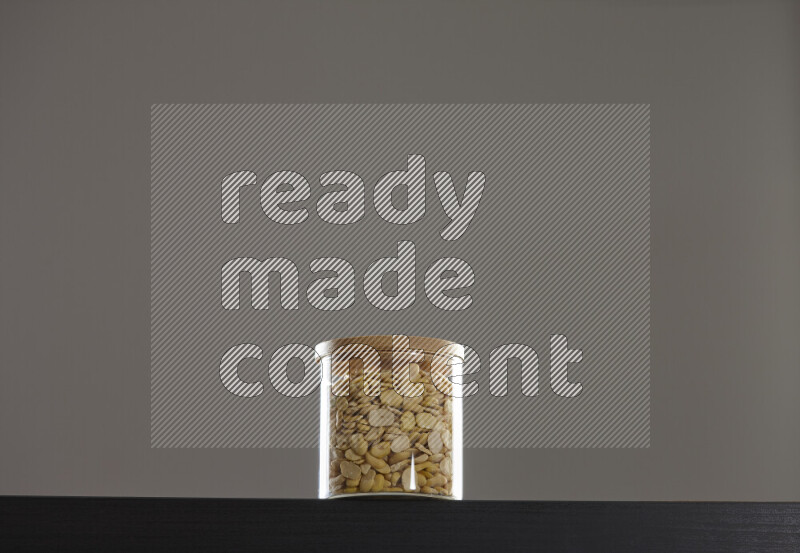 Crushed beans in a glass jar on black background