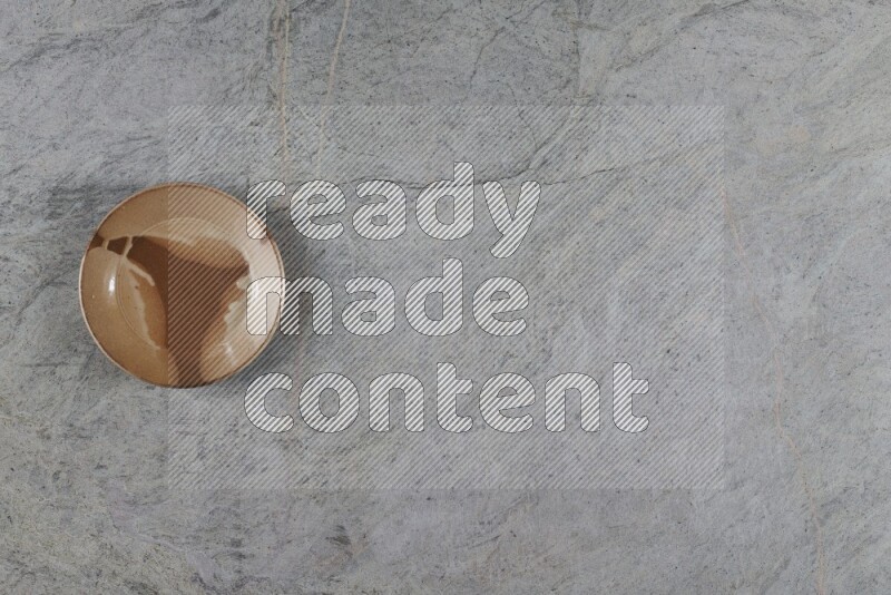 A multicolored pottery plate on grey marble background