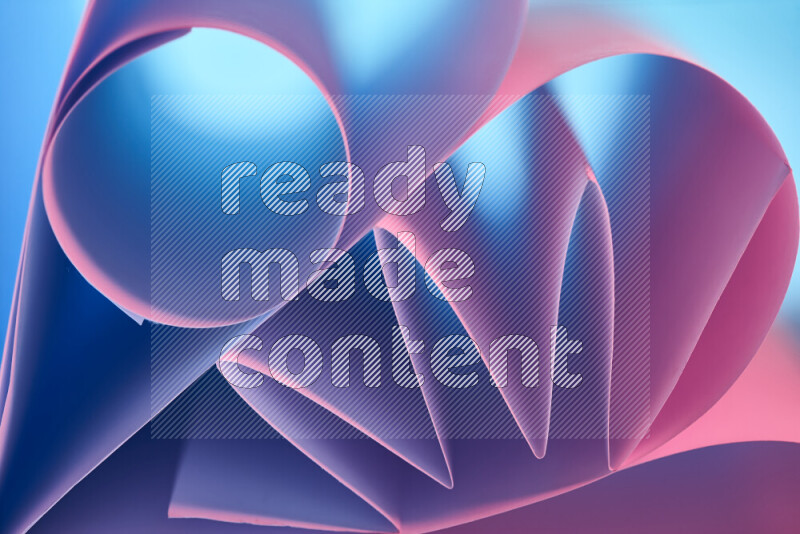 An artistic display of paper folds creating a harmonious blend of geometric shapes, highlighted by soft lighting in blue and pink tones
