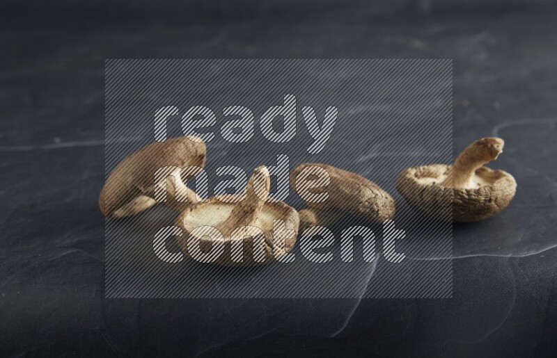 45 degre shiitake mushrooms on a textured black slate background