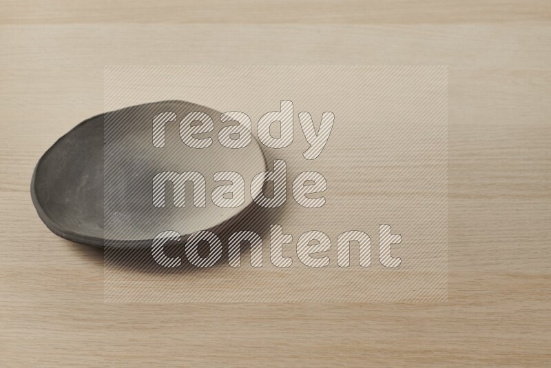 A multicolored pottery plate on light wooden background