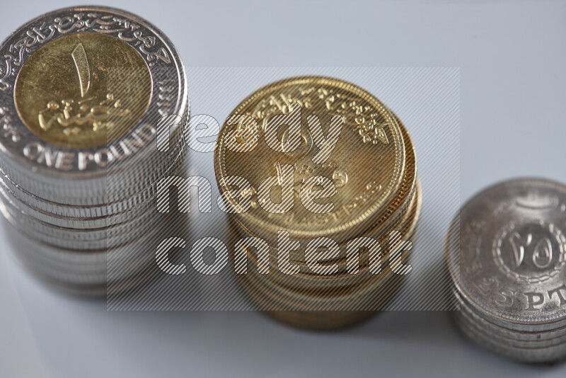 A close-up of scattered mixed Egyptian coins such as One pound, 50 and 25 piasters on grey background